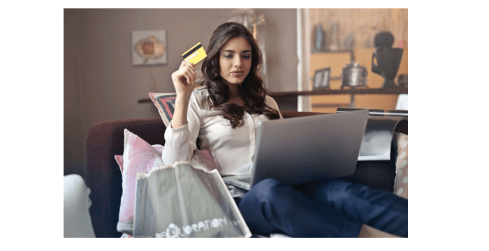woman sat in front of laptop with credit card. Online shopping. Ebit is a procurement consultancy.