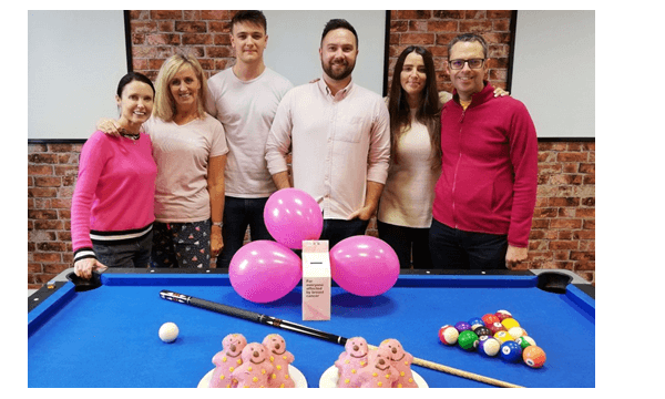 Wear it pink for breast cancer. The Ebit team stood with pink balloons and pink cakes in pink clothing.