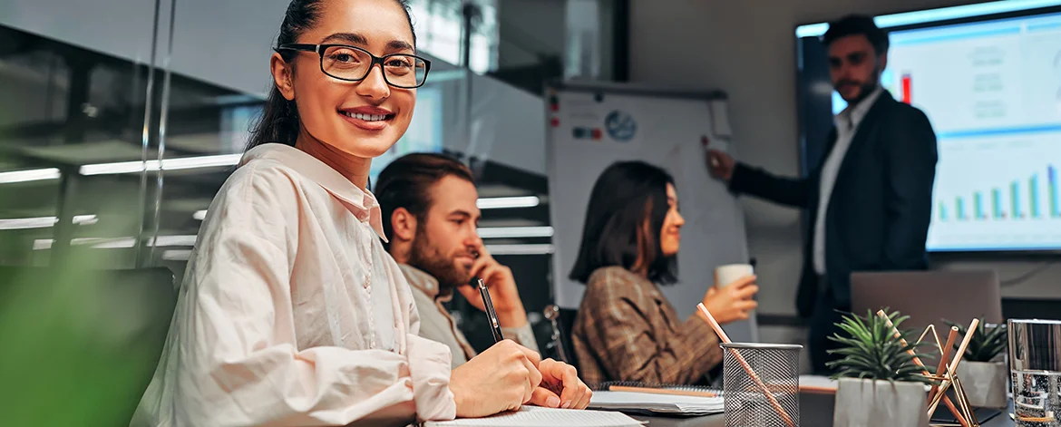 woman-meeting-with-writes-notebook-smiling-partners-presentation-coworker-points-flipchart